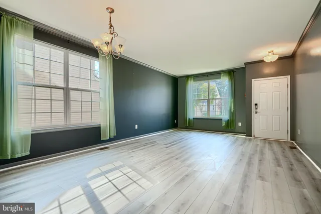 a view of a kitchen with kitchen island a large counter space a sink appliances and cabinets