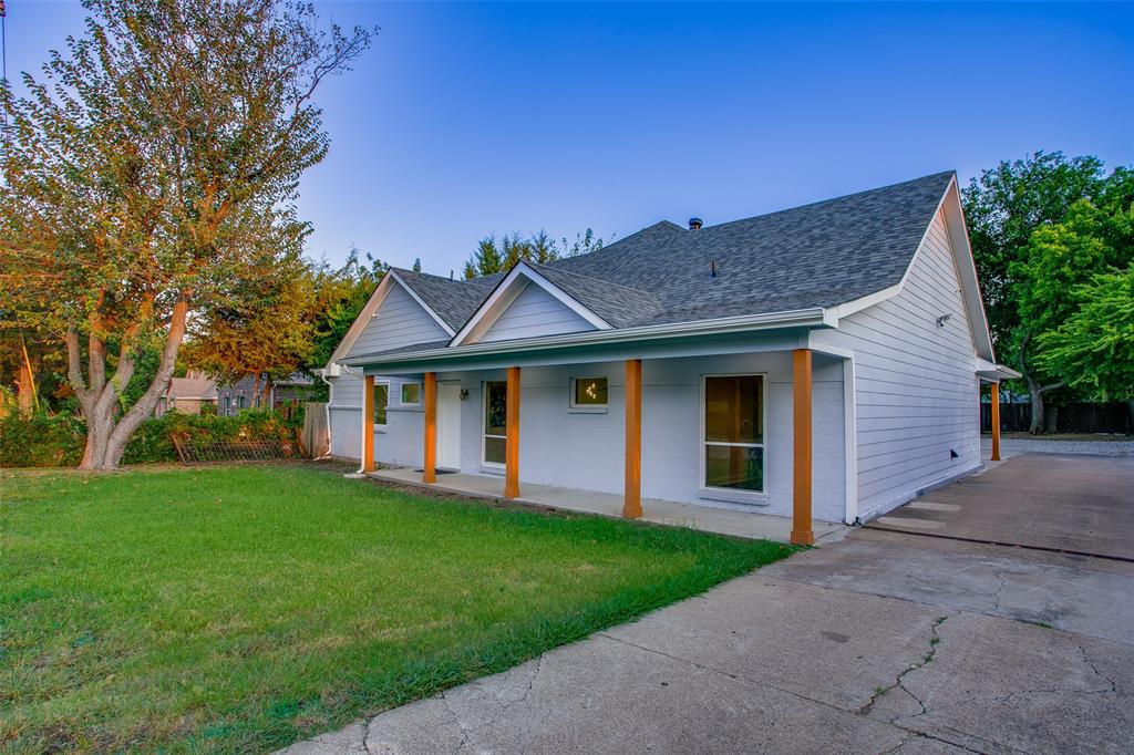 a front view of a house with a garden and yard