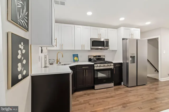 a kitchen with stainless steel appliances a refrigerator stove microwave and sink