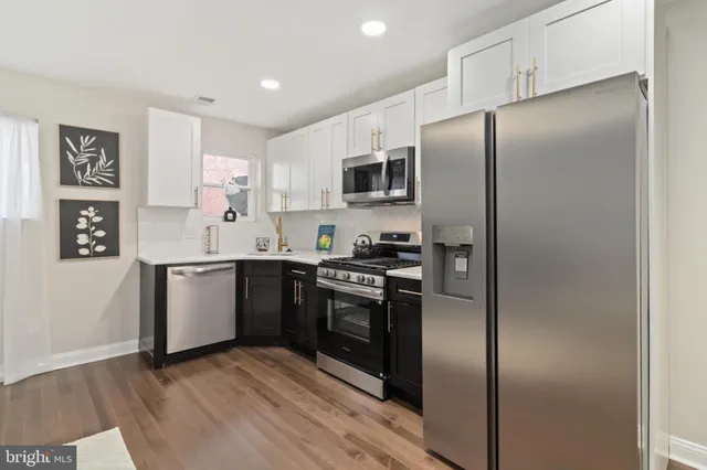 a kitchen with stainless steel appliances granite countertop a refrigerator and a stove top oven