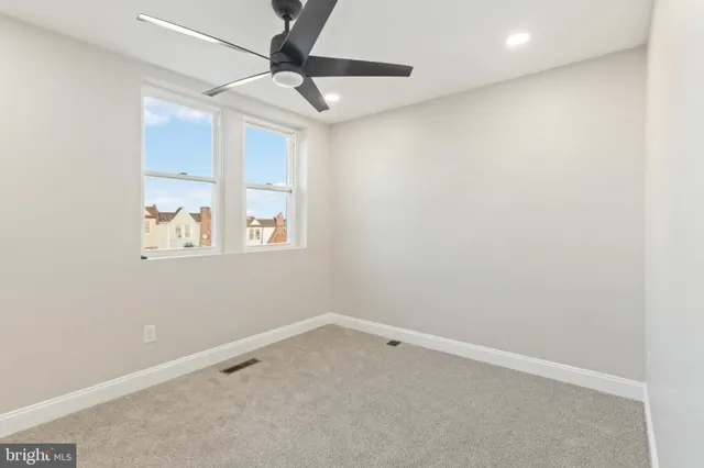 an empty room with closet and a ceiling fan