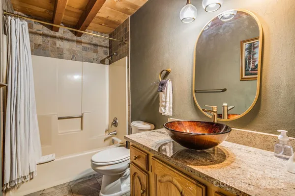a bathroom with a granite countertop toilet sink and mirror