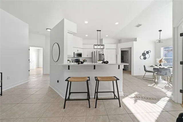a living room with lots of furniture and kitchen view