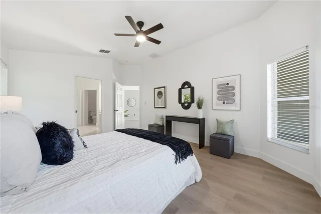 a bedroom with a large bed and a chandelier