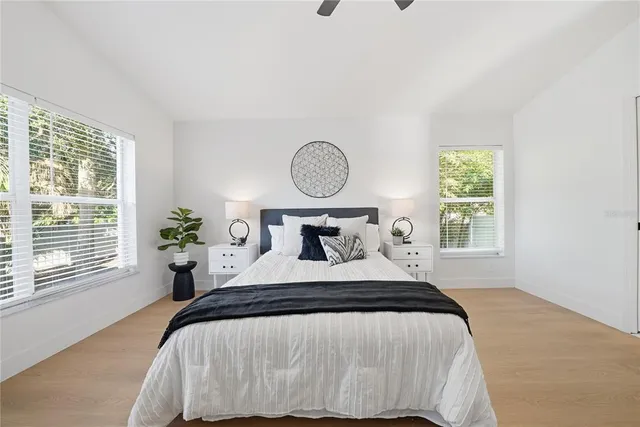 a bedroom with a bed and a window with wooden floor