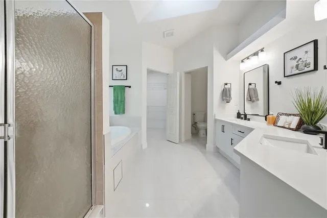 a large white bathroom with sink and mirror