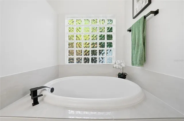 a white bath tub sitting in a bathroom next to a window