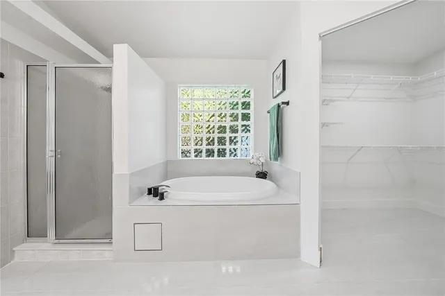 a white bath tub sitting next to a white sink and vanity