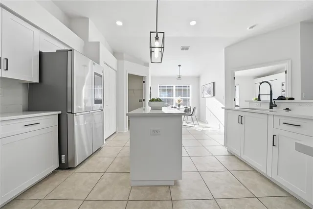a kitchen with kitchen island granite countertop appliances cabinets and a sink