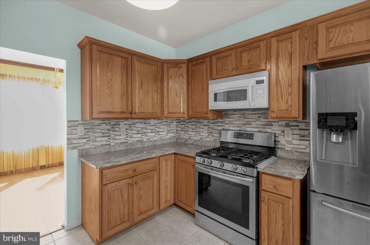 902 Bedford Avenue Reading, PA 19607 - Photo 12 of 48 a kitchen with stainless steel appliances granite countertop a stove microwave and refrigerator