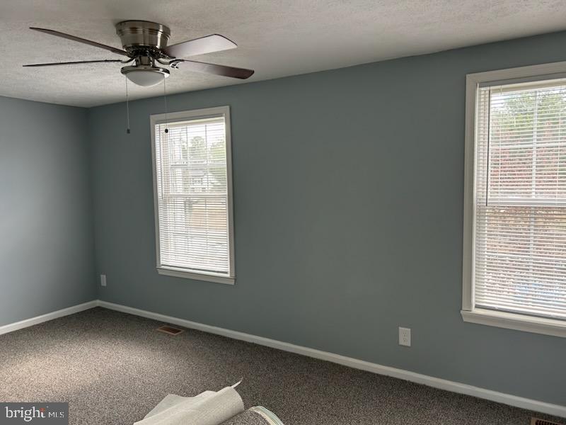 54 Victoria Manor Court Sicklerville, NJ 08081 - Photo 3 of 4 an empty room with a window and a fan