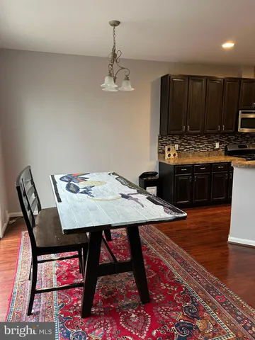 a living room with stainless steel appliances kitchen island granite countertop a stove a refrigerator a sink a microwave and wooden cabinets