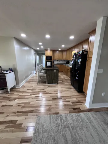 a view of kitchen with refrigerator microwave and cabinets