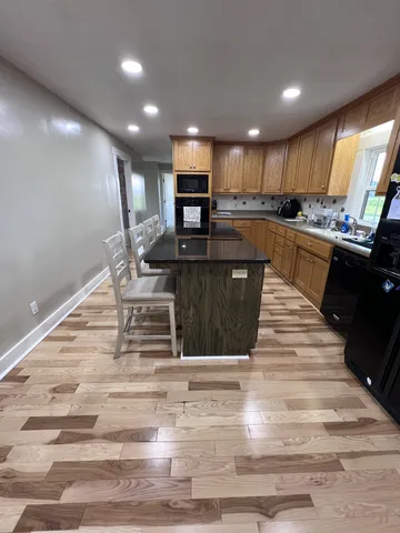 a kitchen with kitchen island granite countertop a sink and a stove