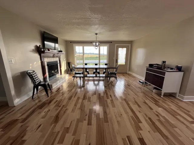 a living room with furniture fireplace and wooden floor