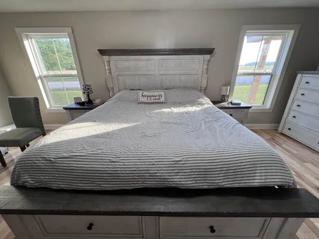 a bedroom with a bed a mirror and a dresser