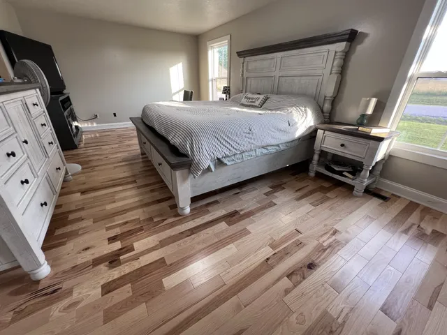 a bedroom with a bed and wooden floor