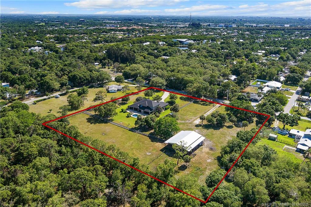 6655 Southwest Gaines Avenue Stuart, FL 34997 - Photo 2 of 48 an aerial view of residential houses with outdoor space and trees