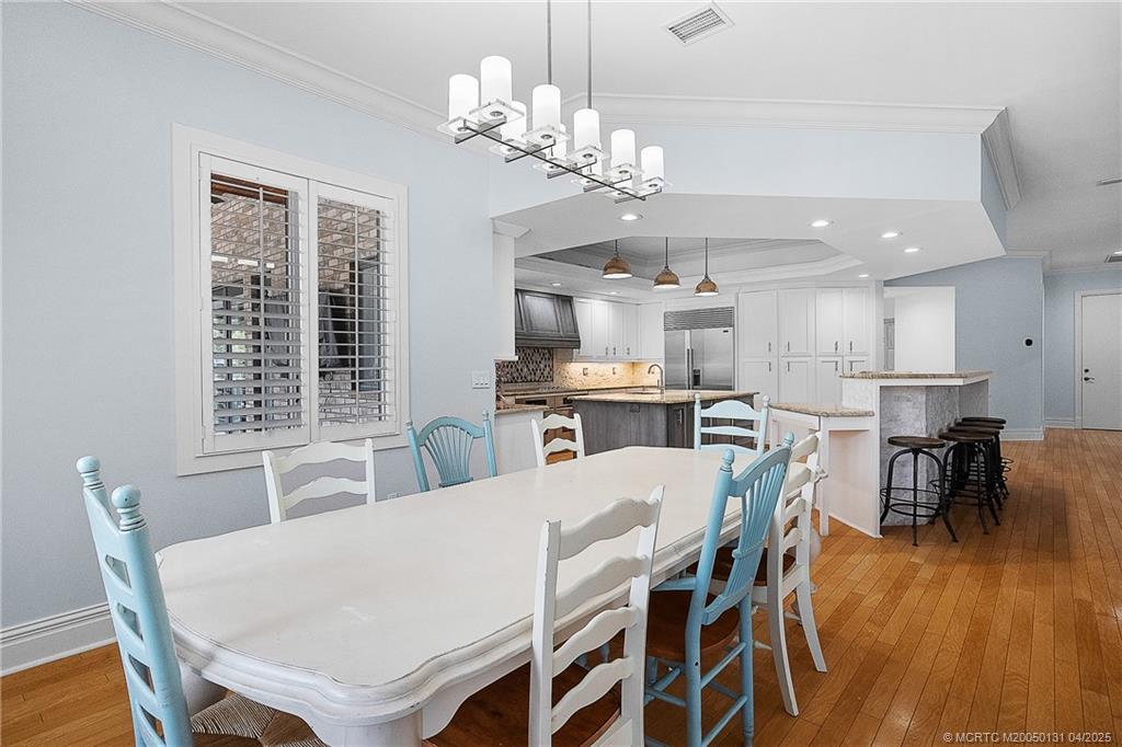 6655 Southwest Gaines Avenue Stuart, FL 34997 - Photo 21 of 48 a view of a dining room with furniture wooden floor and chandelier
