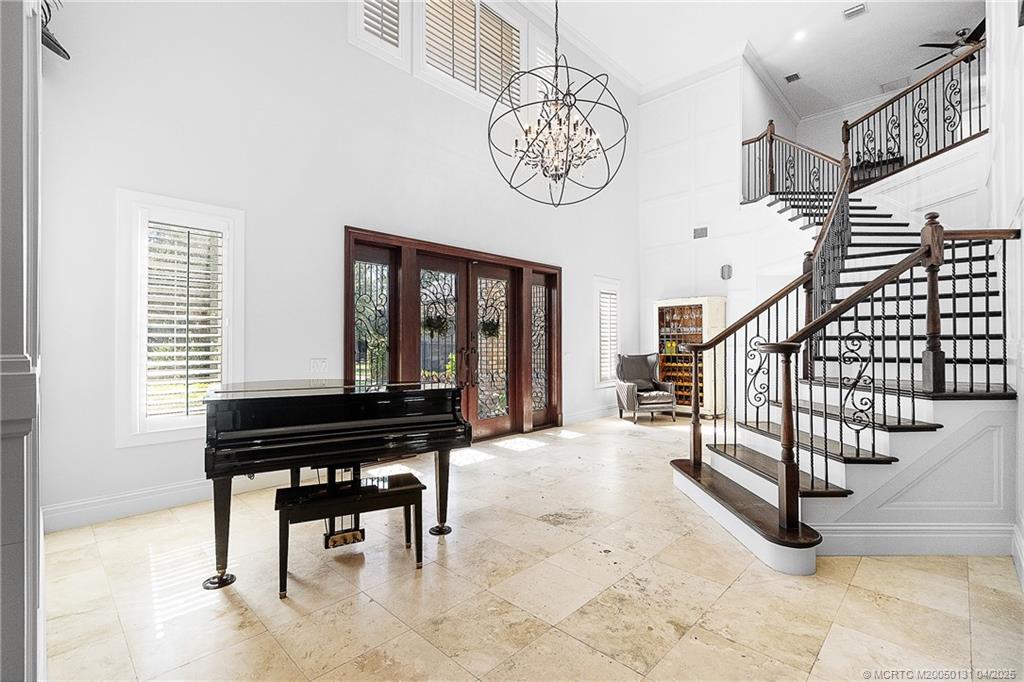 6655 Southwest Gaines Avenue Stuart, FL 34997 - Photo 3 of 48 a view of a livingroom with furniture stairs a chandelier and wooden floor