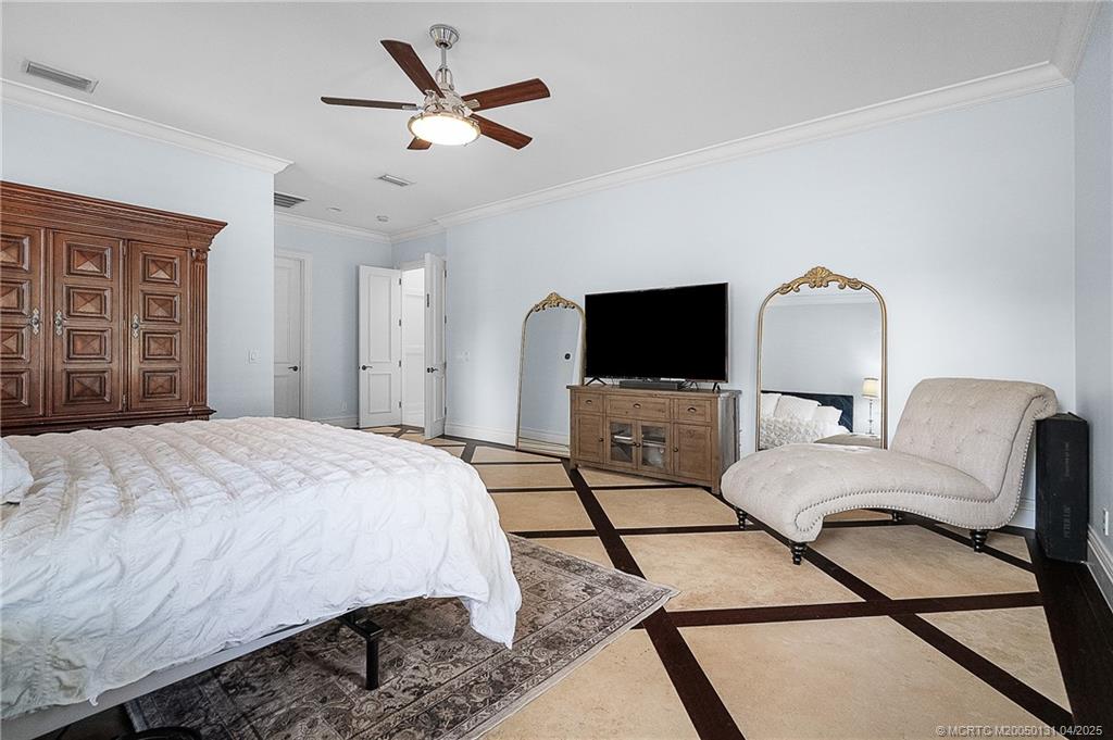 6655 Southwest Gaines Avenue Stuart, FL 34997 - Photo 31 of 48 a spacious bedroom with a bed and a flat screen tv