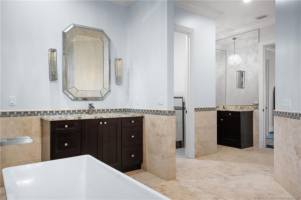 6655 Southwest Gaines Avenue Stuart, FL 34997 - Photo 33 of 48 a bathroom with a double vanity sink and a mirror