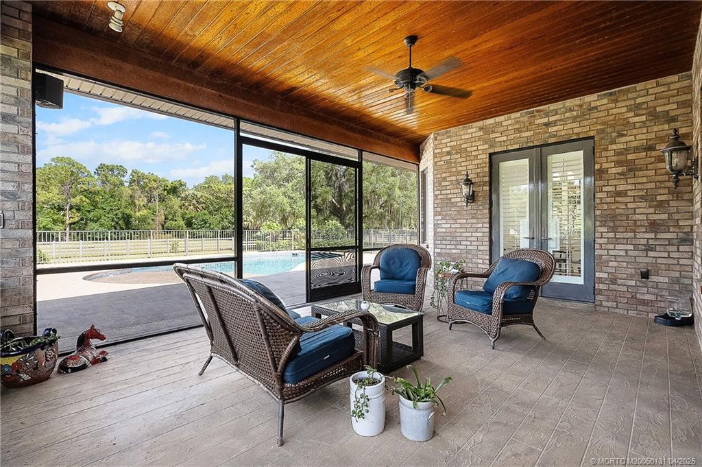 6655 Southwest Gaines Avenue Stuart, FL 34997 - Photo 38 of 48 a living room with furniture and a floor to ceiling window