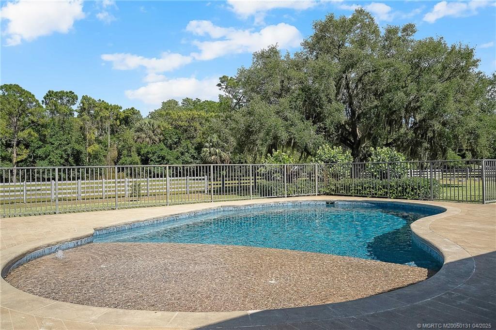 6655 Southwest Gaines Avenue Stuart, FL 34997 - Photo 39 of 48 a view of a swimming pool with an outdoor space and seating area