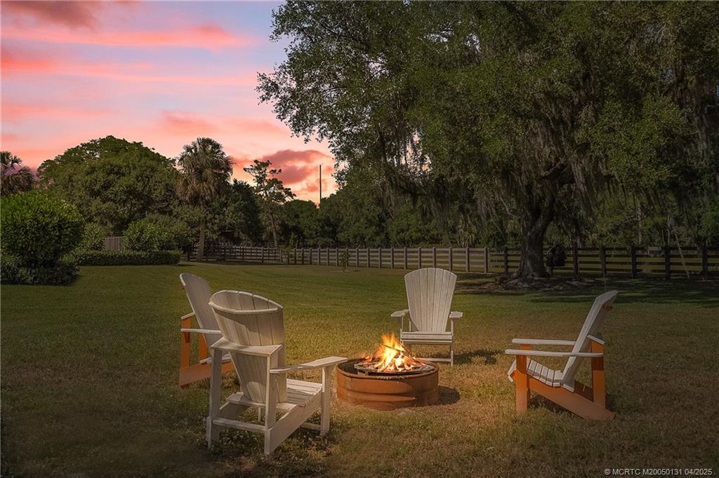 6655 Southwest Gaines Avenue Stuart, FL 34997 - Photo 40 of 48 a view of a lake with a table and chairs in the patio