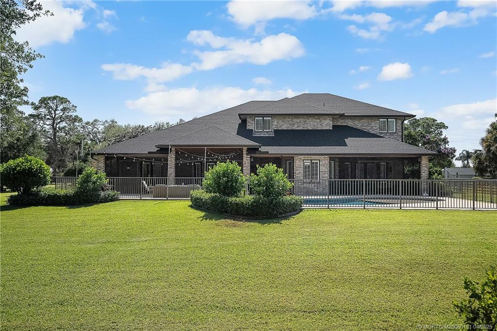 6655 Southwest Gaines Avenue Stuart, FL 34997 - Photo 44 of 48 a view of a house with a yard potted plants and a large tree