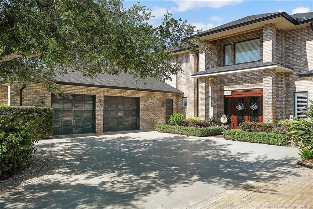 6655 Southwest Gaines Avenue Stuart, FL 34997 - Photo 47 of 48 a front view of a house with a yard and garage