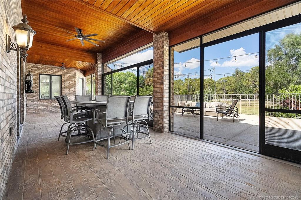 6655 Southwest Gaines Avenue Stuart, FL 34997 - Photo 7 of 48 a dining room with furniture water view and a floor to ceiling window