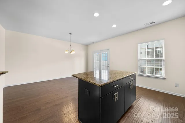 a kitchen with a sink a counter space and wooden floor