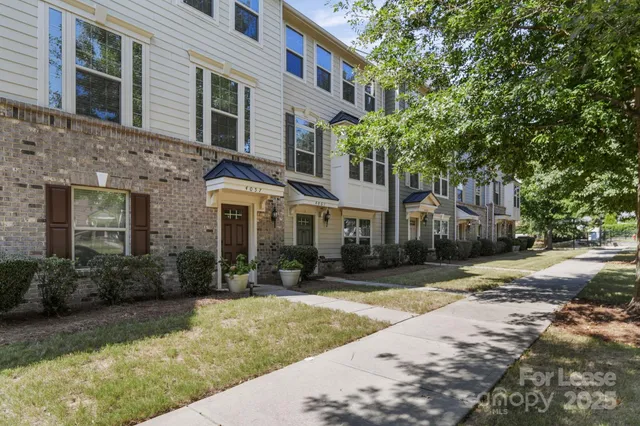 a front view of a house with a yard and tree s