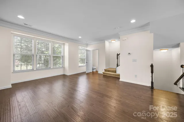 a view of empty room with wooden floor and windows