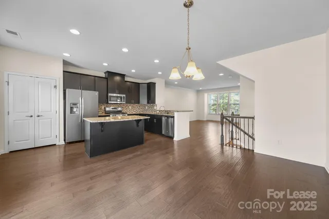 a view of kitchen with refrigerator stove and wooden floor