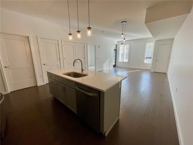 a kitchen with a sink a faucet cabinets and wooden floor