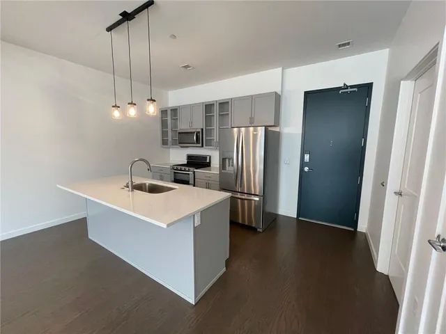 a kitchen with a sink a refrigerator a microwave and a stove