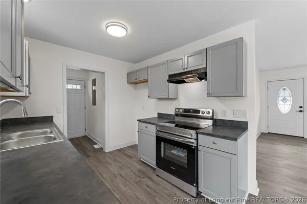 a kitchen with stainless steel appliances granite countertop a sink stove and cabinets