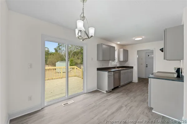 a kitchen that has a sink a stove and cabinets