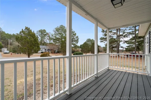a view of a hallway with wooden floor and a chandelier