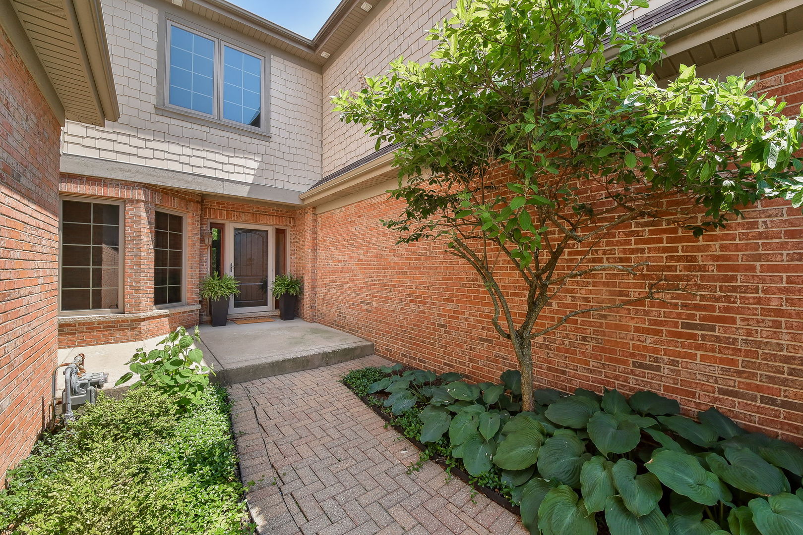2003 Mackenzie Place Wheaton, IL 60187 - Photo 2 of 25 a front view of a house with a yard and potted plants