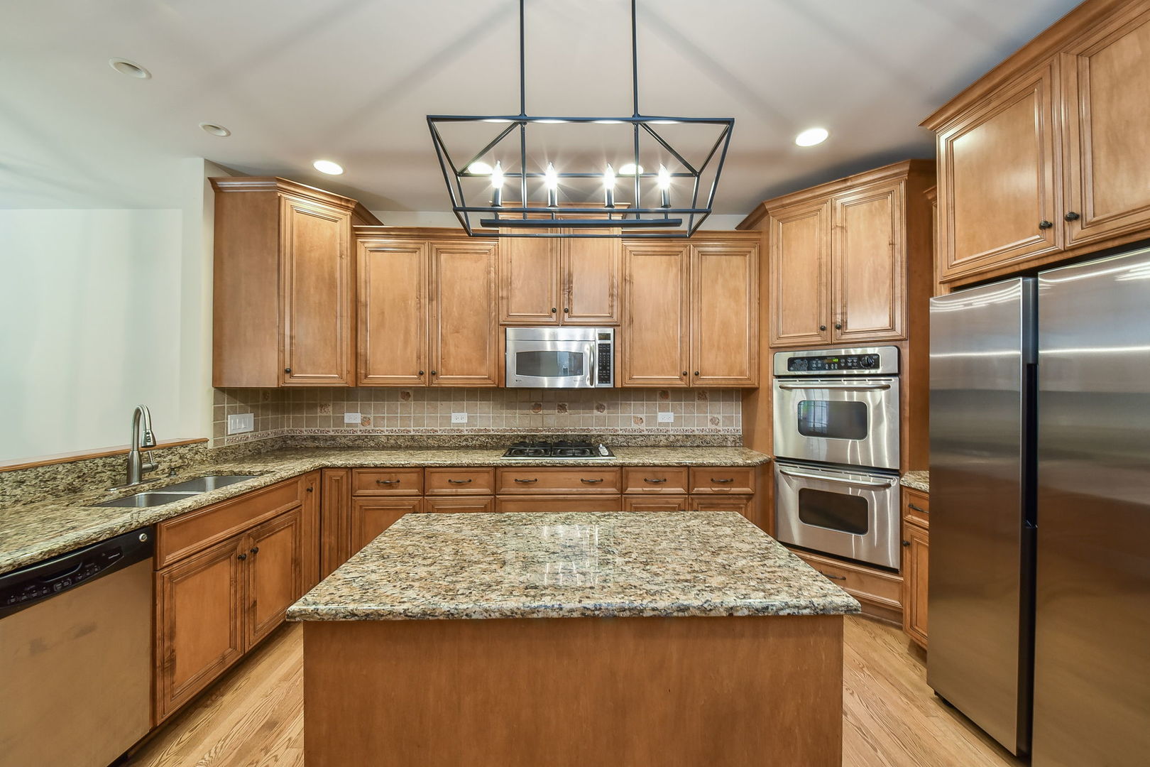 2003 Mackenzie Place Wheaton, IL 60187 - Photo 8 of 25 a kitchen with kitchen island granite countertop a sink stove and refrigerator