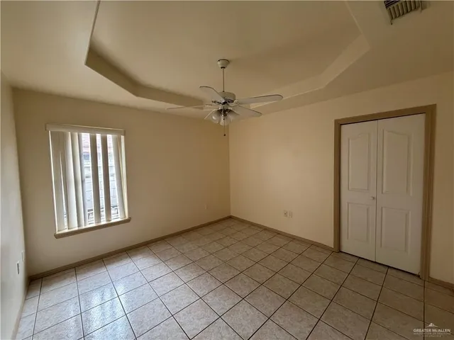 an empty room with windows and fan