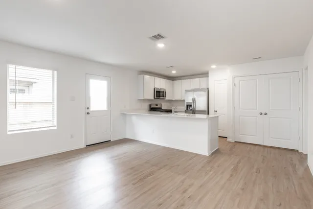 a kitchen with refrigerator cabinets and wooden floor
