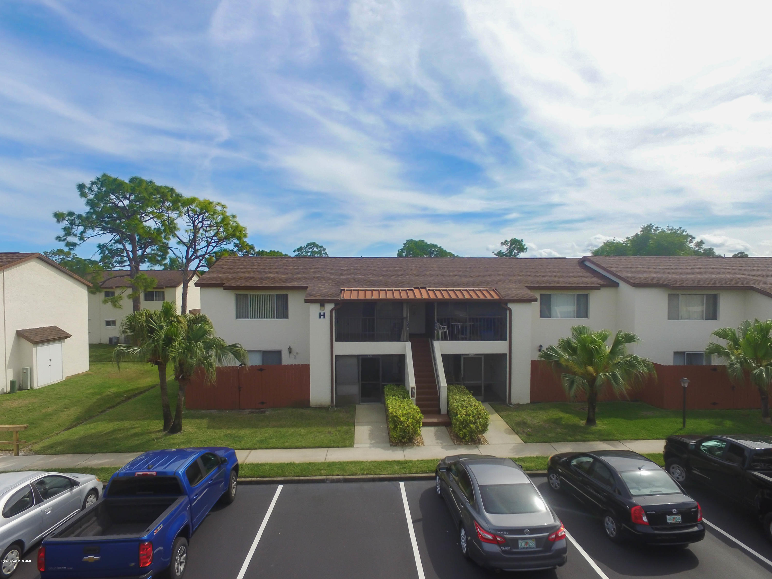 610 North Wickham Road, Unit 74 Melbourne, FL 32935 - Photo 1 of 46 a front view of a house with a yard table and chairs
