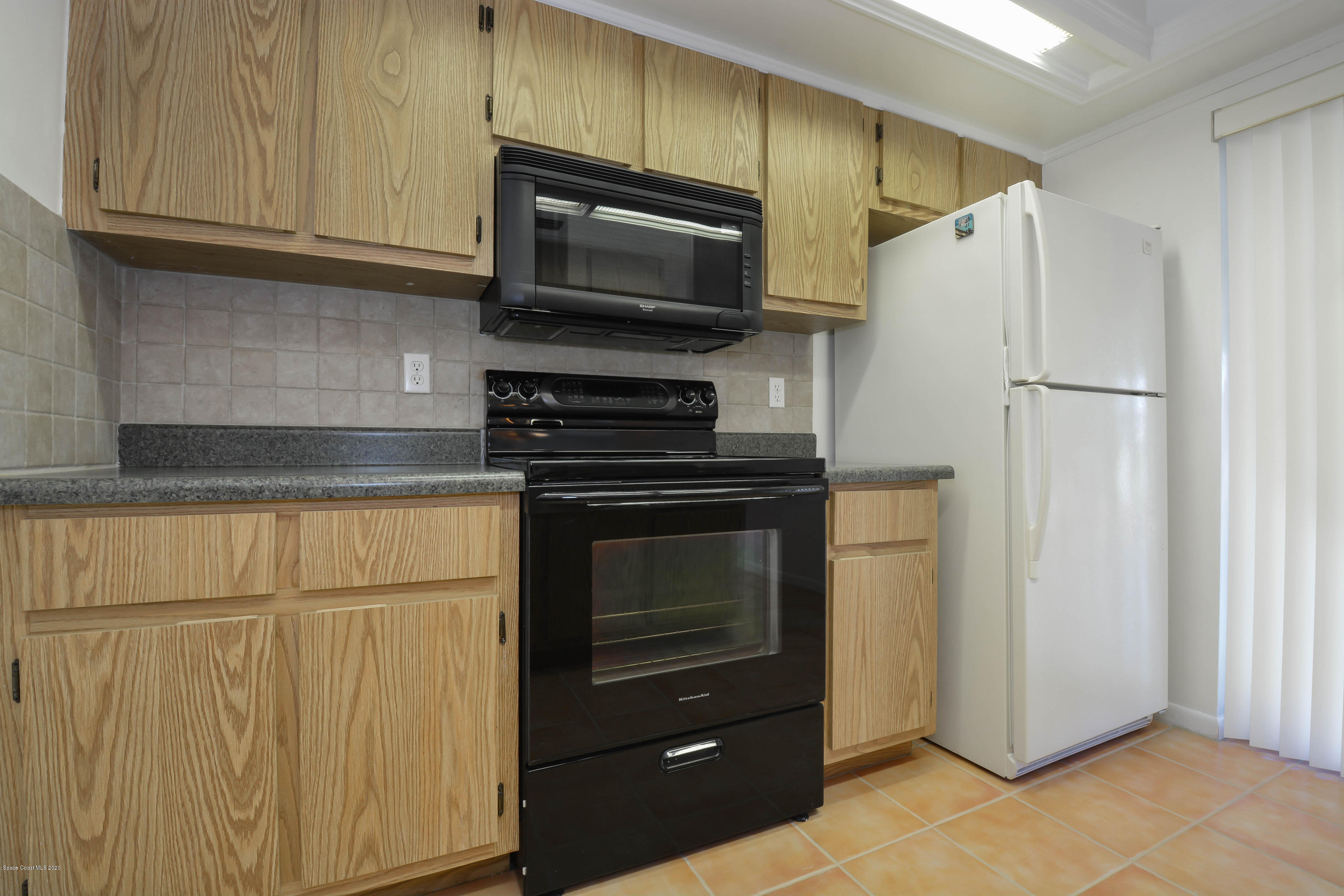 610 North Wickham Road, Unit 74 Melbourne, FL 32935 - Photo 12 of 46 a kitchen with granite countertop cabinets and steel stainless steel appliances
