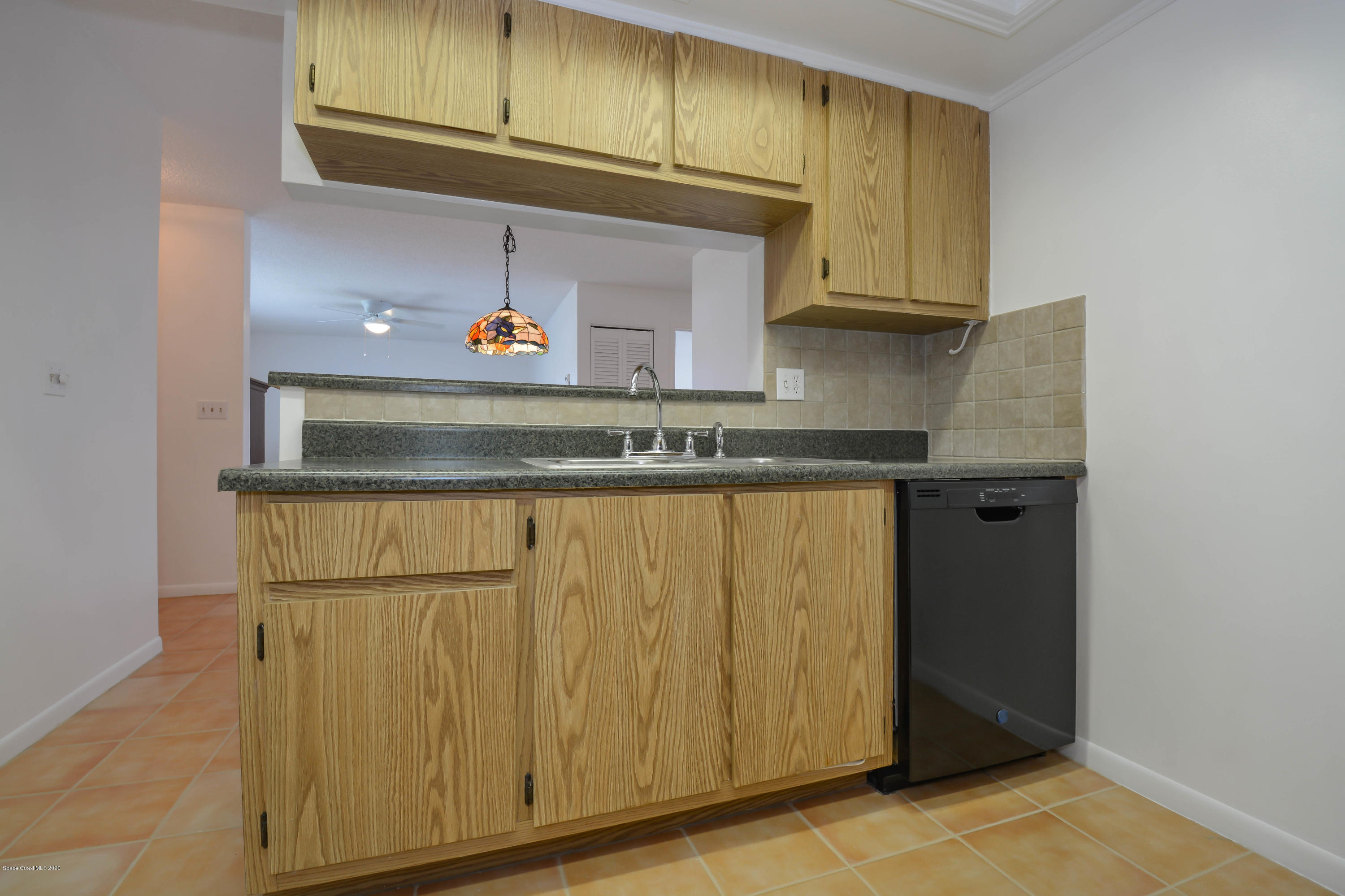 610 North Wickham Road, Unit 74 Melbourne, FL 32935 - Photo 13 of 46 a kitchen with granite countertop cabinets and a refrigerator