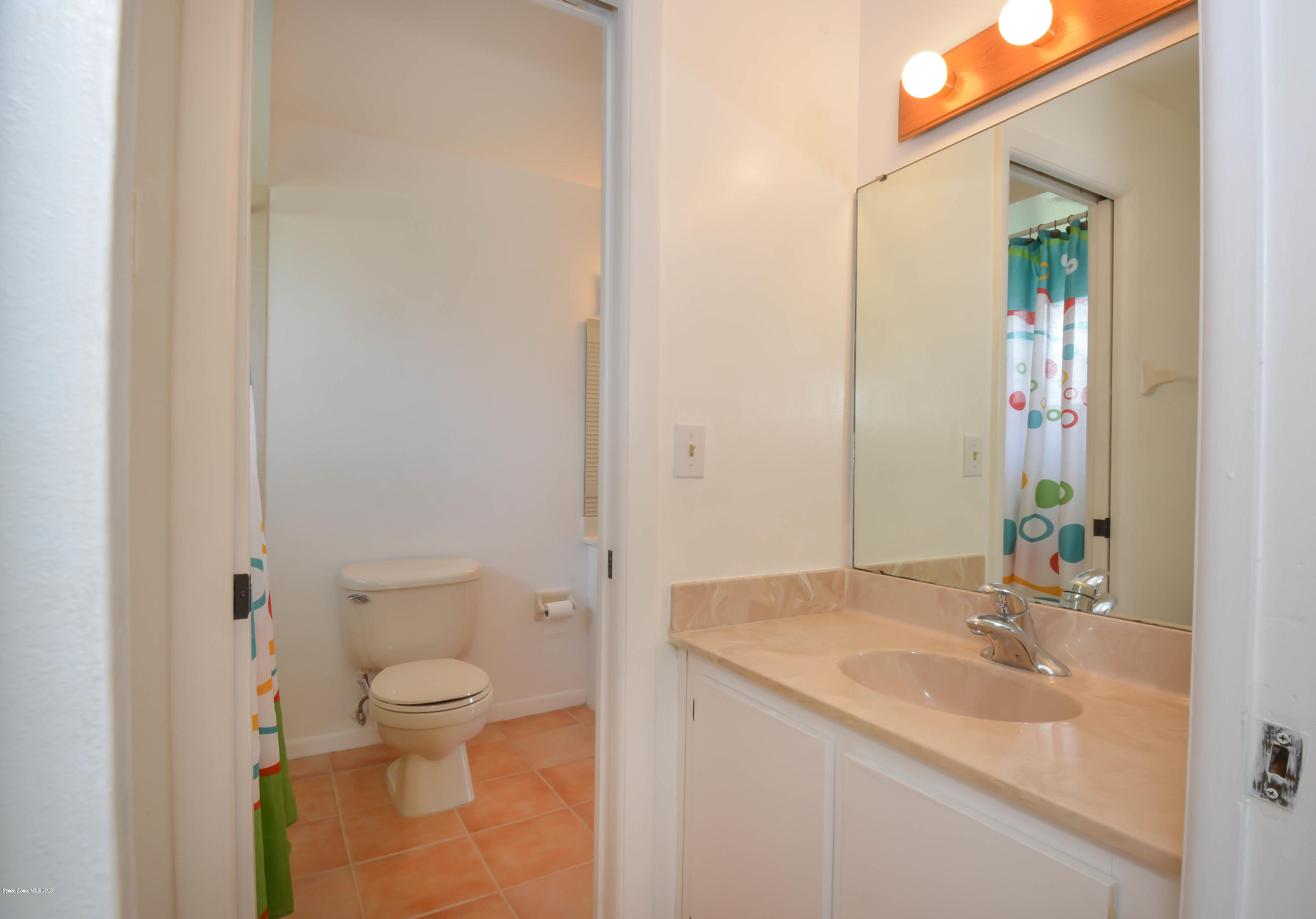 610 North Wickham Road, Unit 74 Melbourne, FL 32935 - Photo 18 of 46 a bathroom with a granite countertop sink a toilet and a mirror