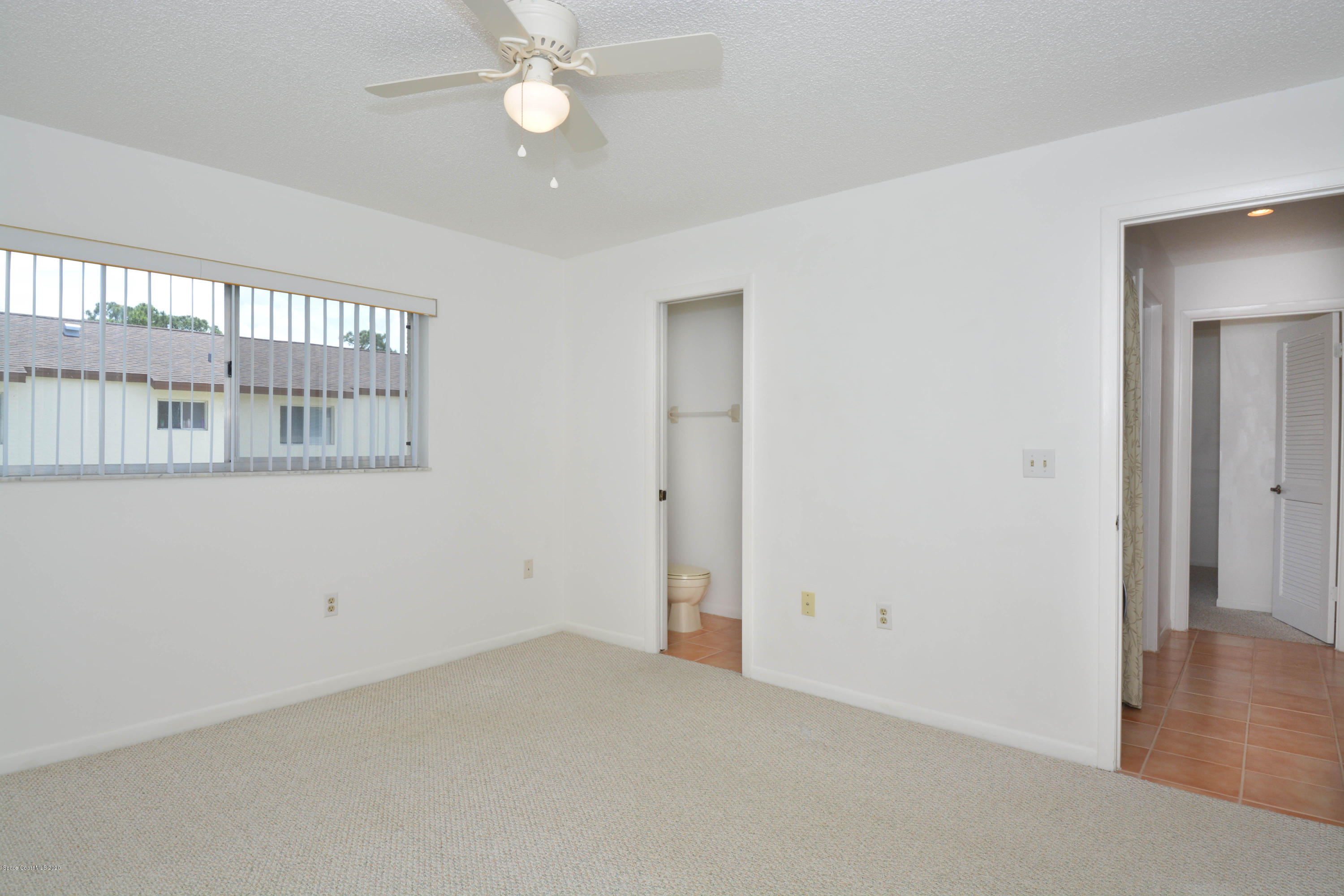 610 North Wickham Road, Unit 74 Melbourne, FL 32935 - Photo 38 of 46 an empty room with wooden floor fan and windows